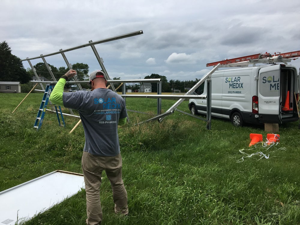 solar maintenance worker in New York adjusting a ladder working by the solar medix van